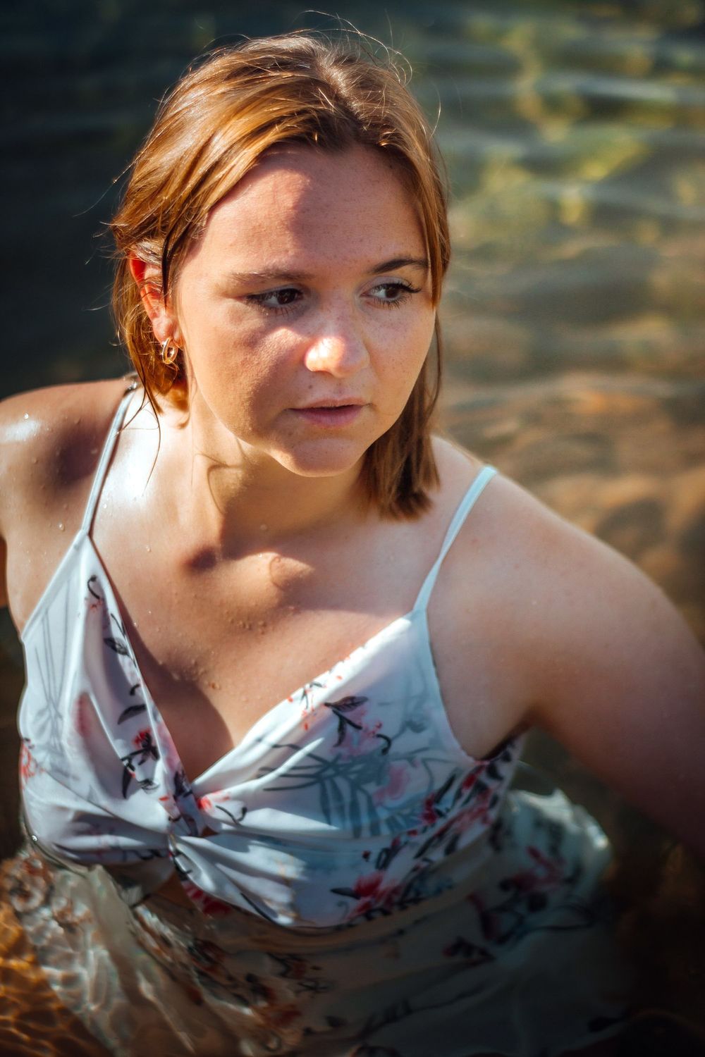 Portrait de Clara dans l'eau, capturé dans une ambiance calme et rafraîchissante, mettant en valeur la fluidité et la beauté naturelle du mo
