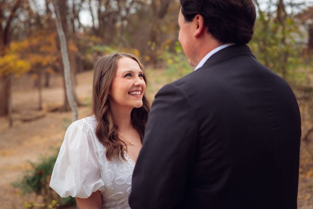 A romantic moment captured between two people in formal attire during fall season.