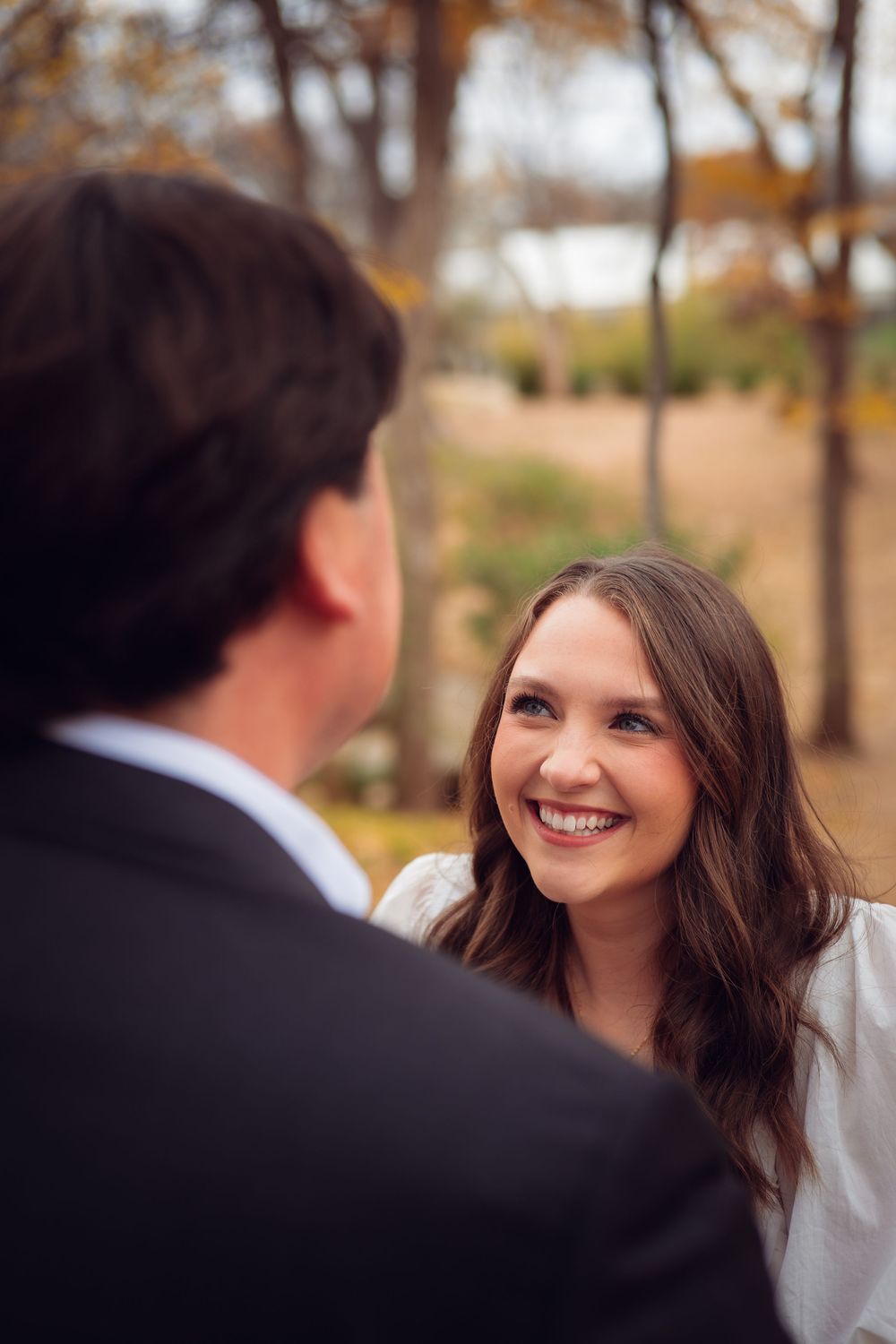 A joyful exchange between two people during an autumn photoshoot outdoors.