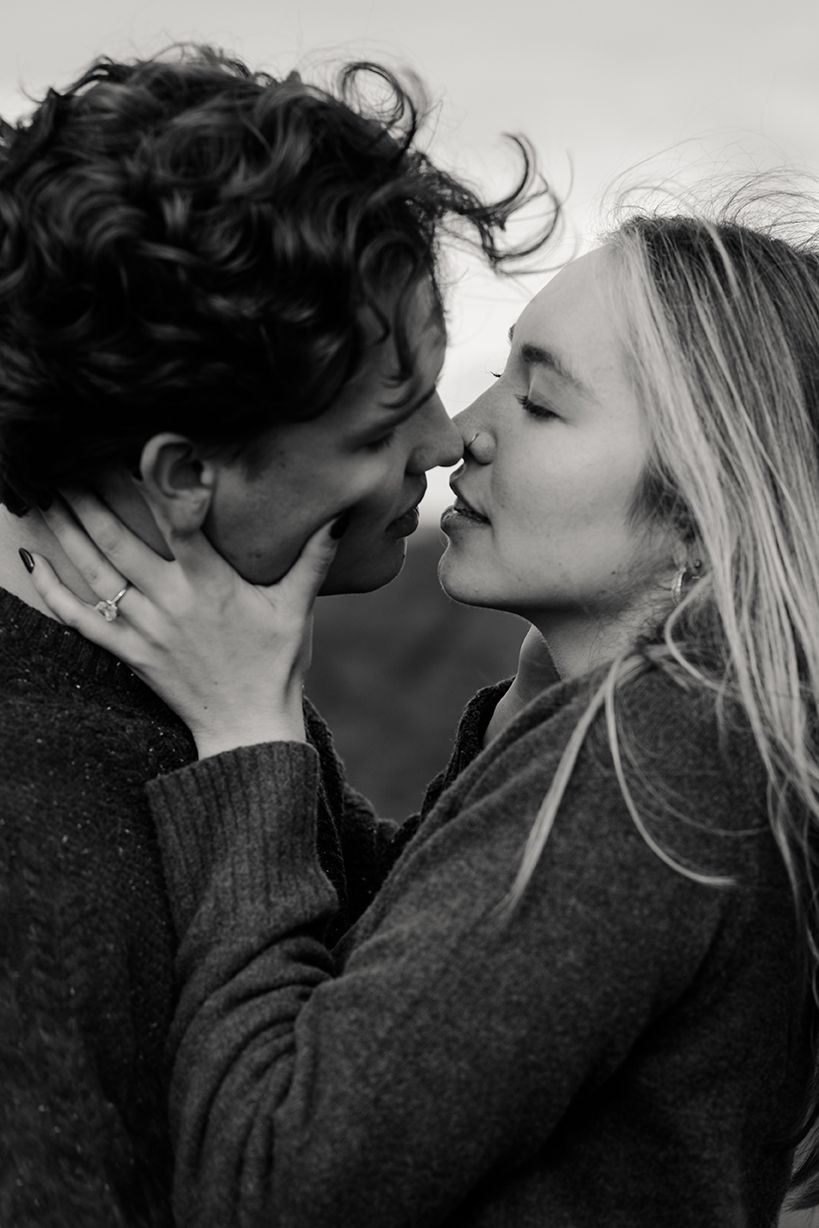 a couple holding each other close and going for a passionate kiss, during their surprise proposal photo session in Ireland