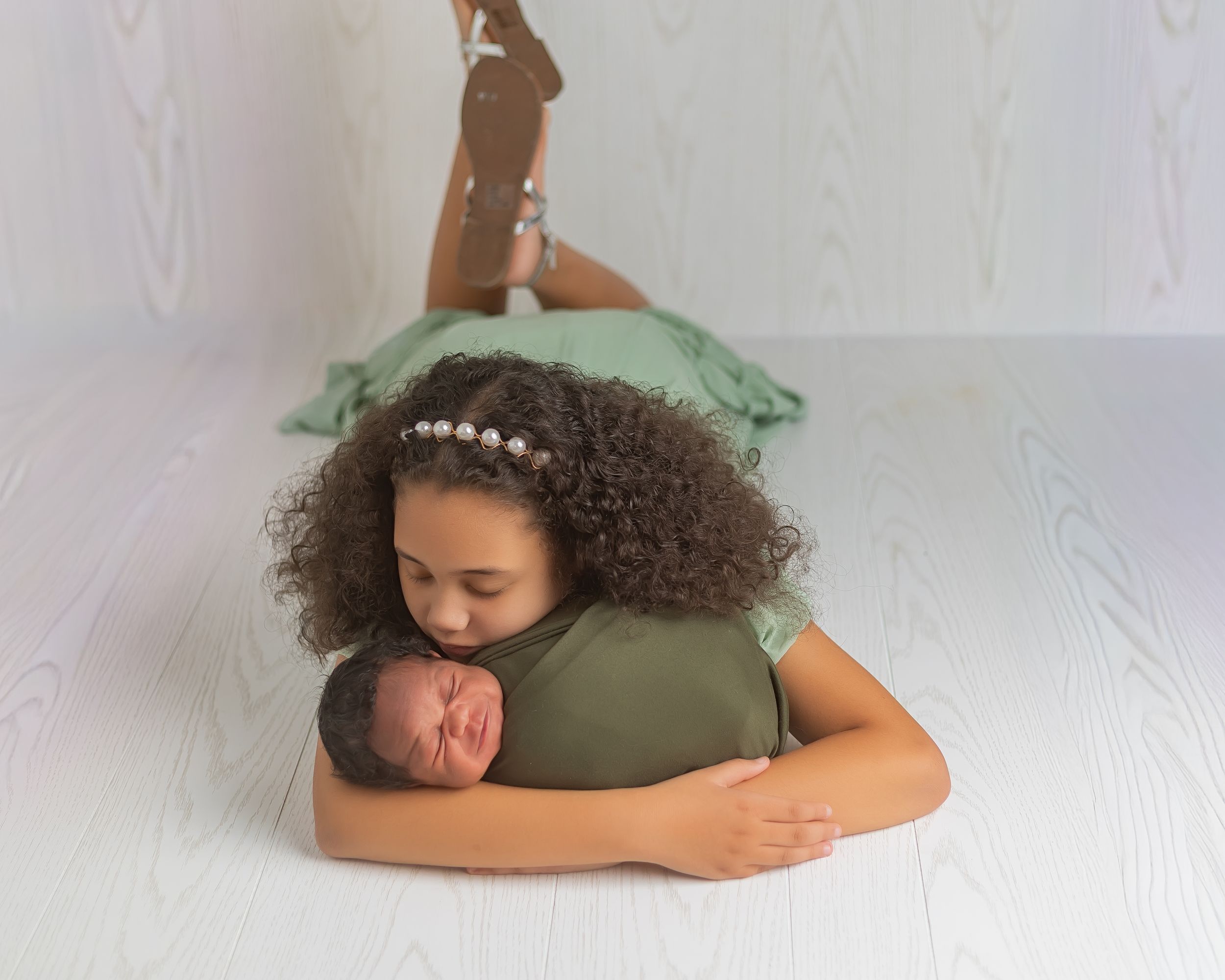A sequence of photos showing a person with curly hair lying down on a white surface in different poses.