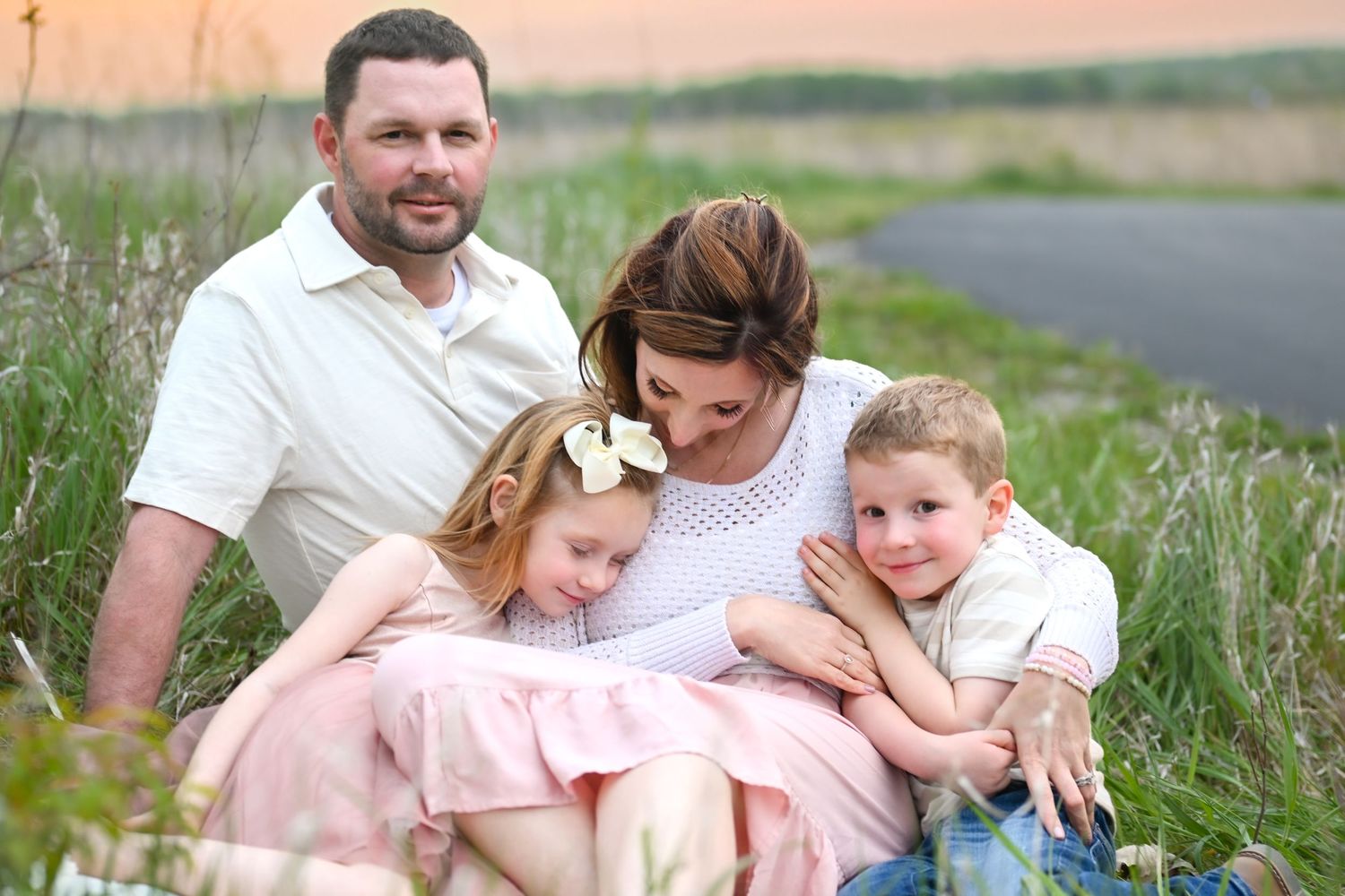 Family sits on ground in an embrace at Prophetstown State Park.