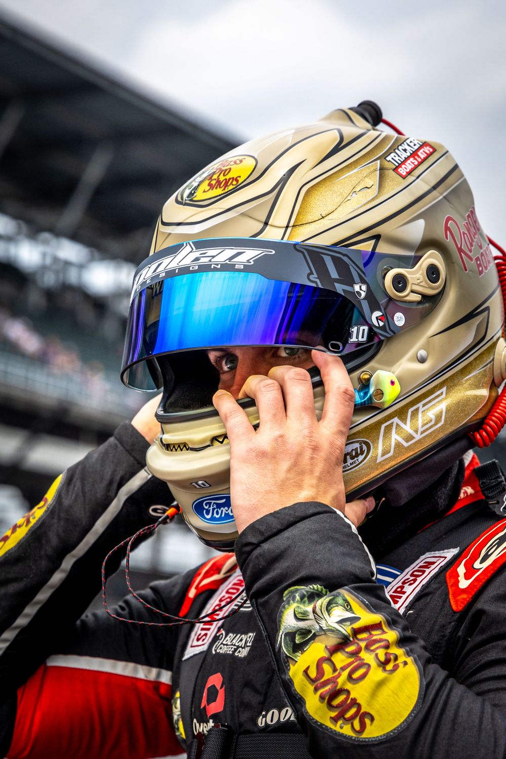 Close-up of gold racing helmets with reflective visors at NASCAR event.