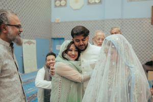 An emotional embrace during a wedding ceremony in a decorated room.