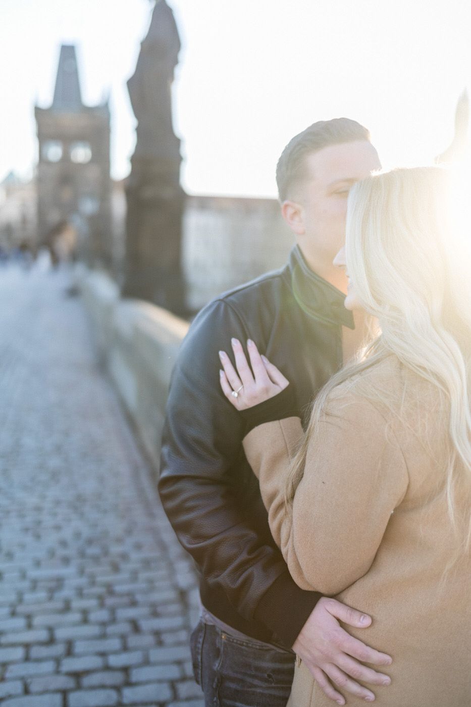 Intimate moment captured on Prague's cobblestone bridge at sunset.