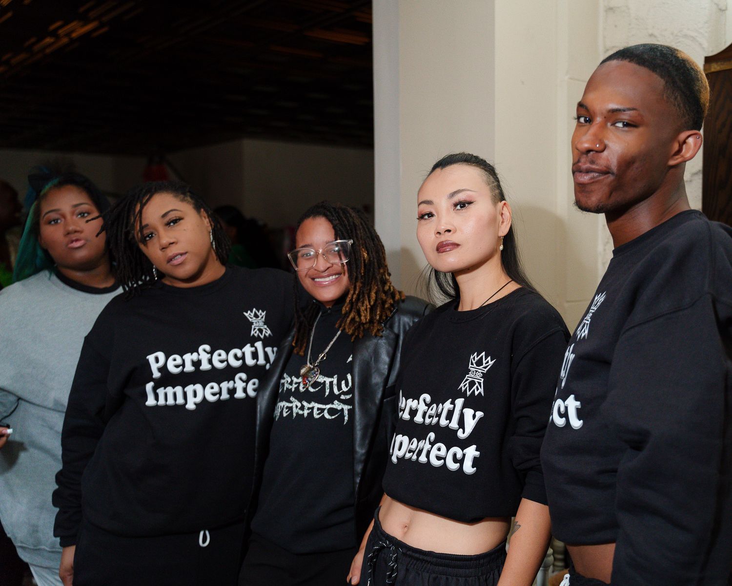 Group wearing matching black sweatshirts with 'Perfectly Imperfect' text.