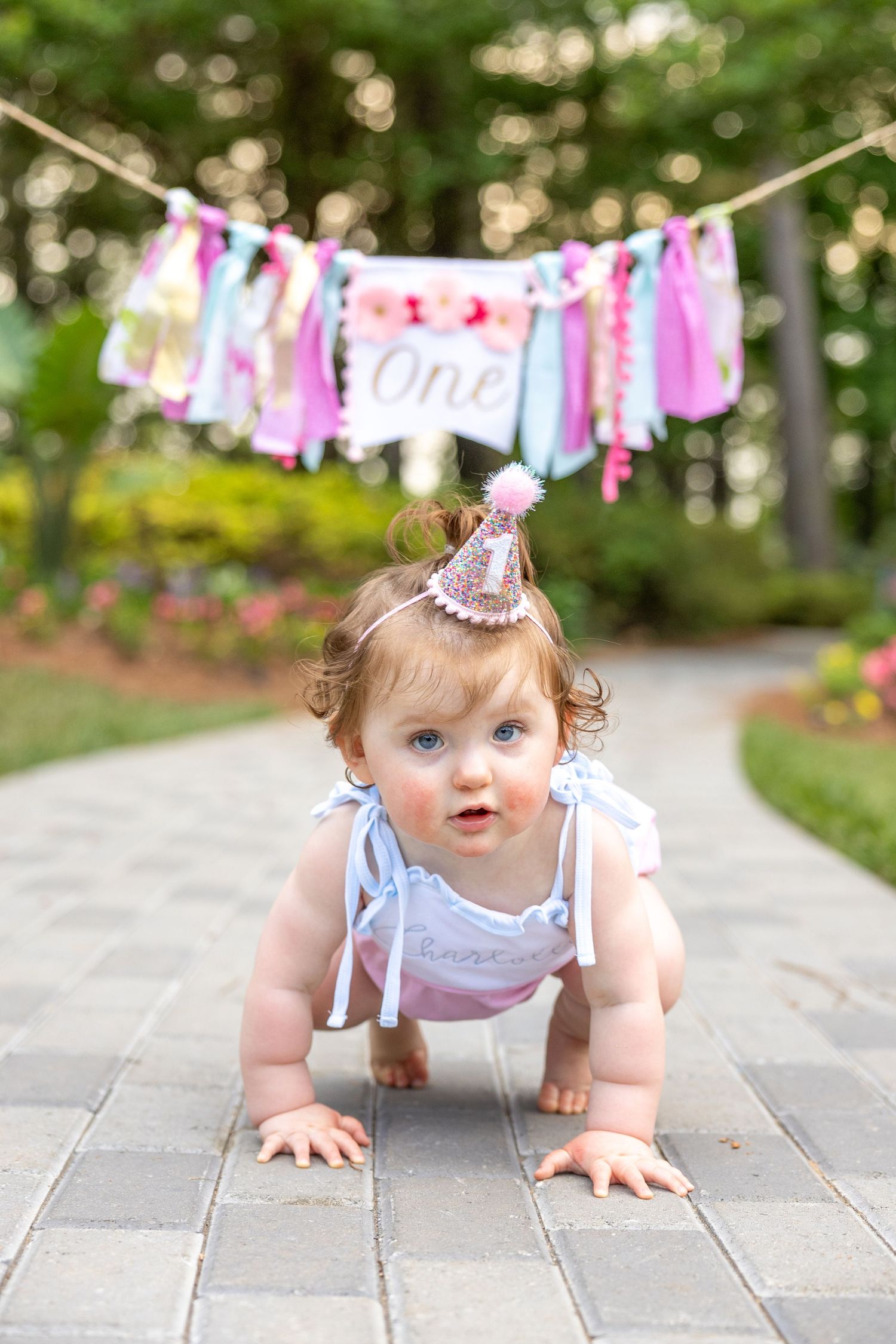 Baby girl in pink 1st birthday hat - cake smash session in Raleigh NC