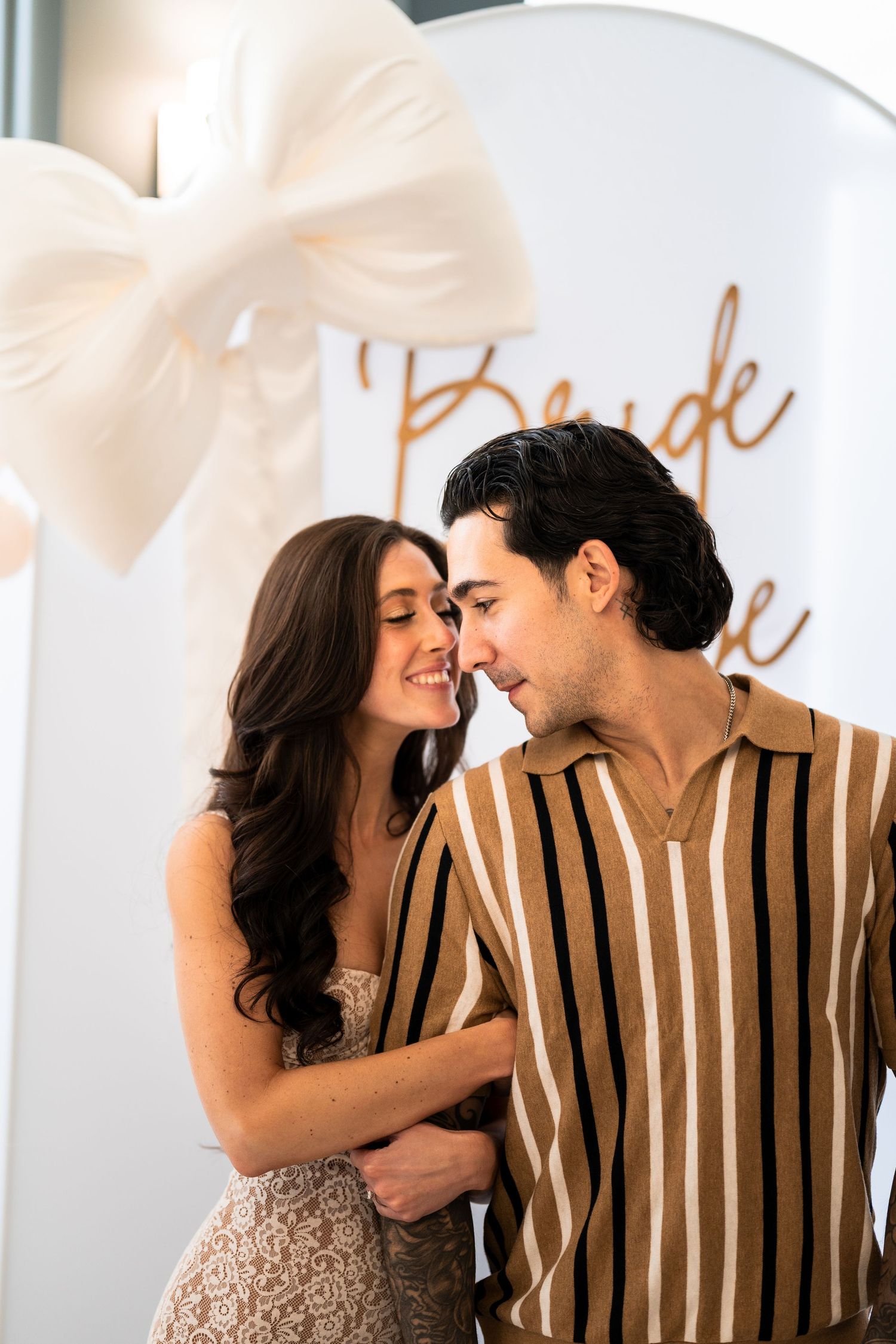 A romantic couple sharing an intimate moment against a light background with script text.
