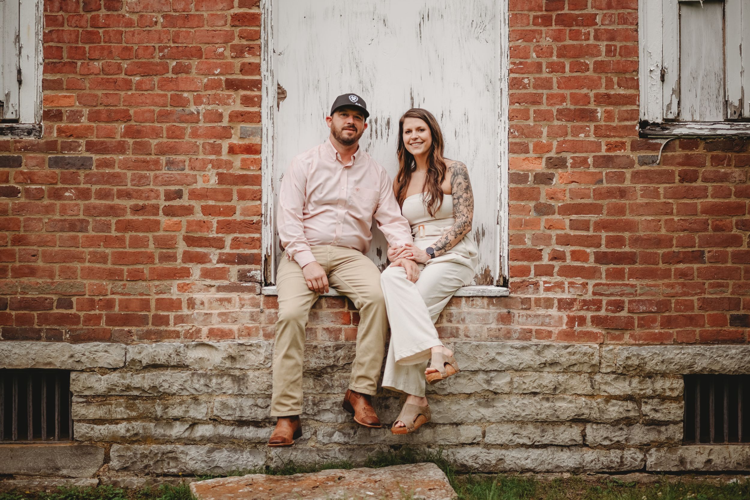 Family photo session against vintage brick wall with white trim.