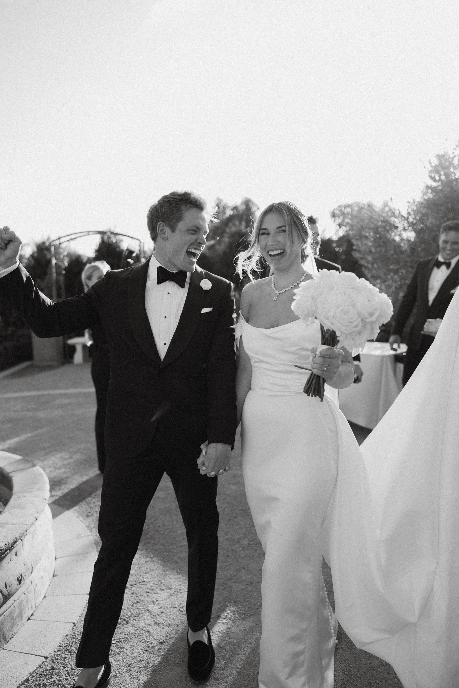 Black and white photo of bride and groom celebrating just married at Tuscan Rose Ranch in Santa Paula, California
