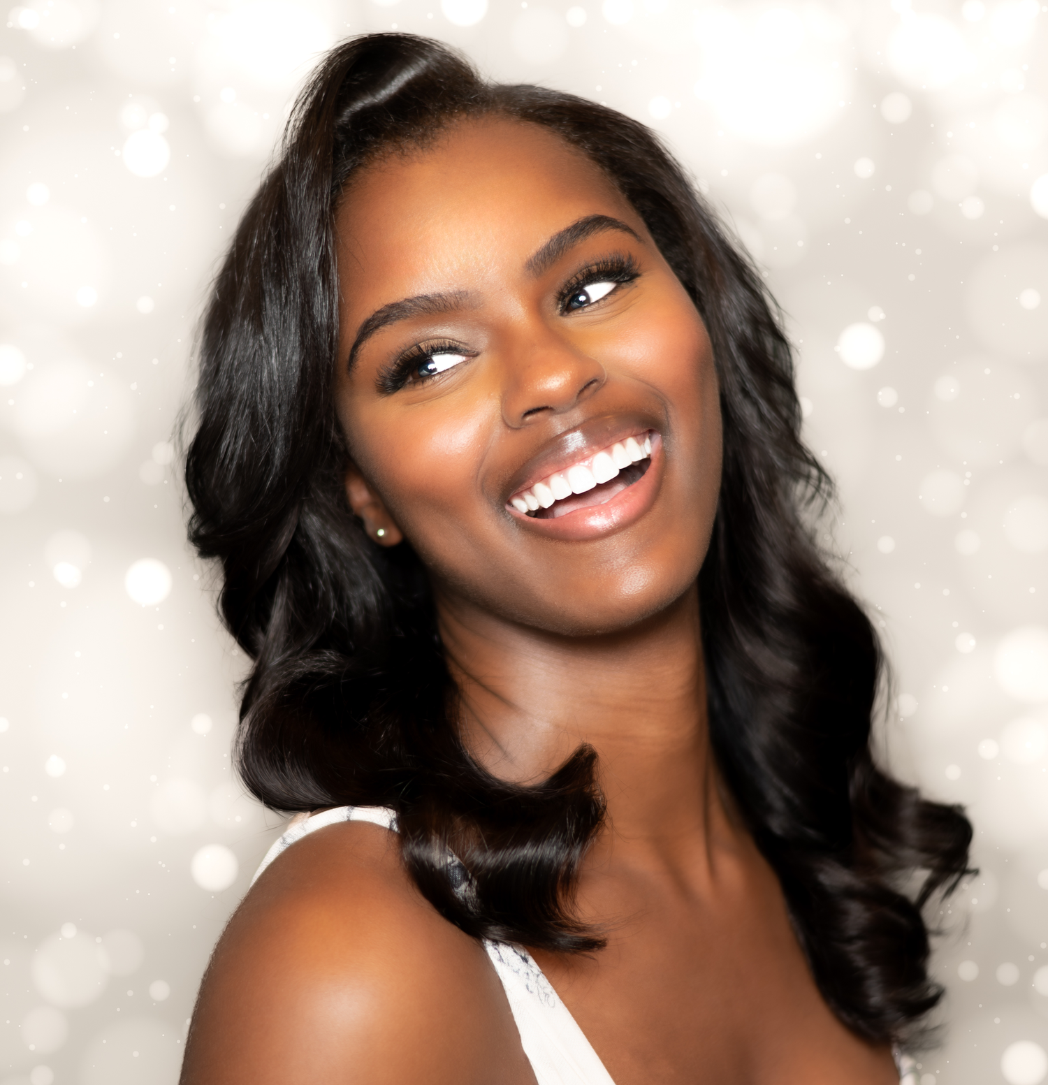 Studio portraits with soft lighting and sparkly background effects.