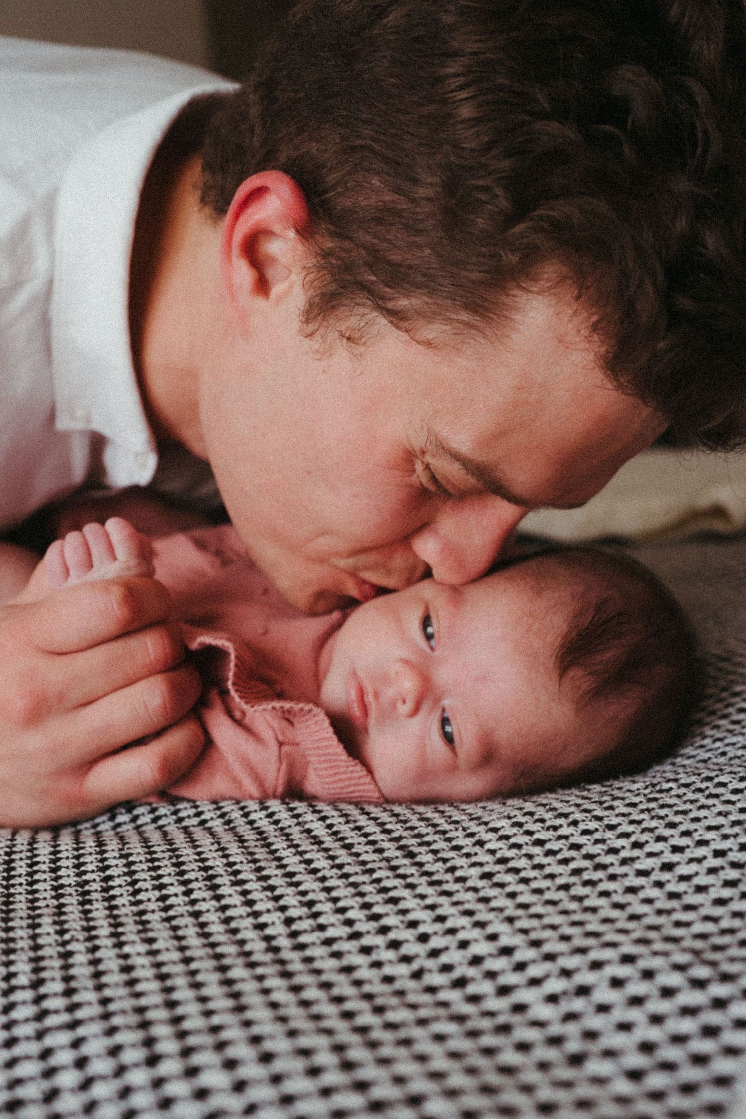 Sweet sequence showing parent sharing tender moments with their newborn on patterned fabric.