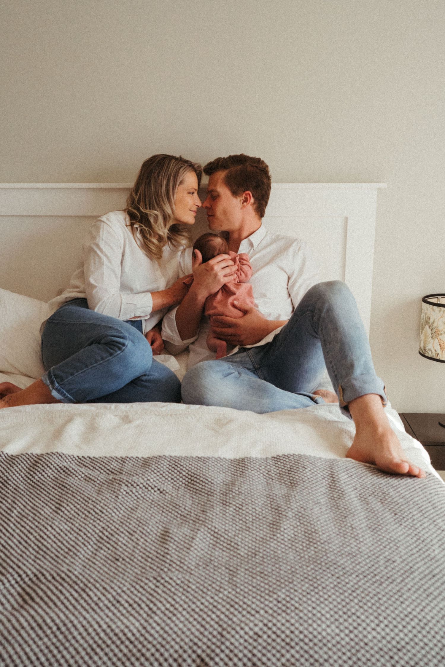 Couple in casual attire sharing affectionate moments while relaxing on bed.
