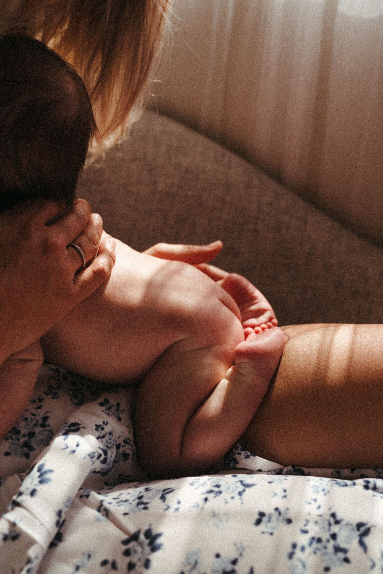 Gentle moments captured in soft window light on a gray couch.