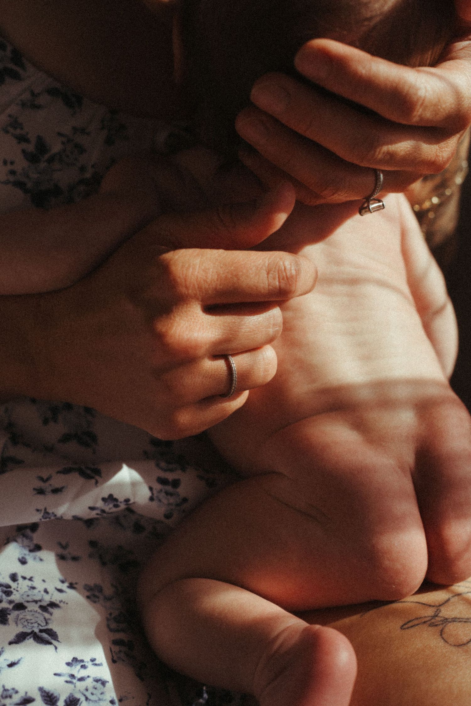 Close-up sequence of hands tenderly holding and caressing against a floral patterned background.