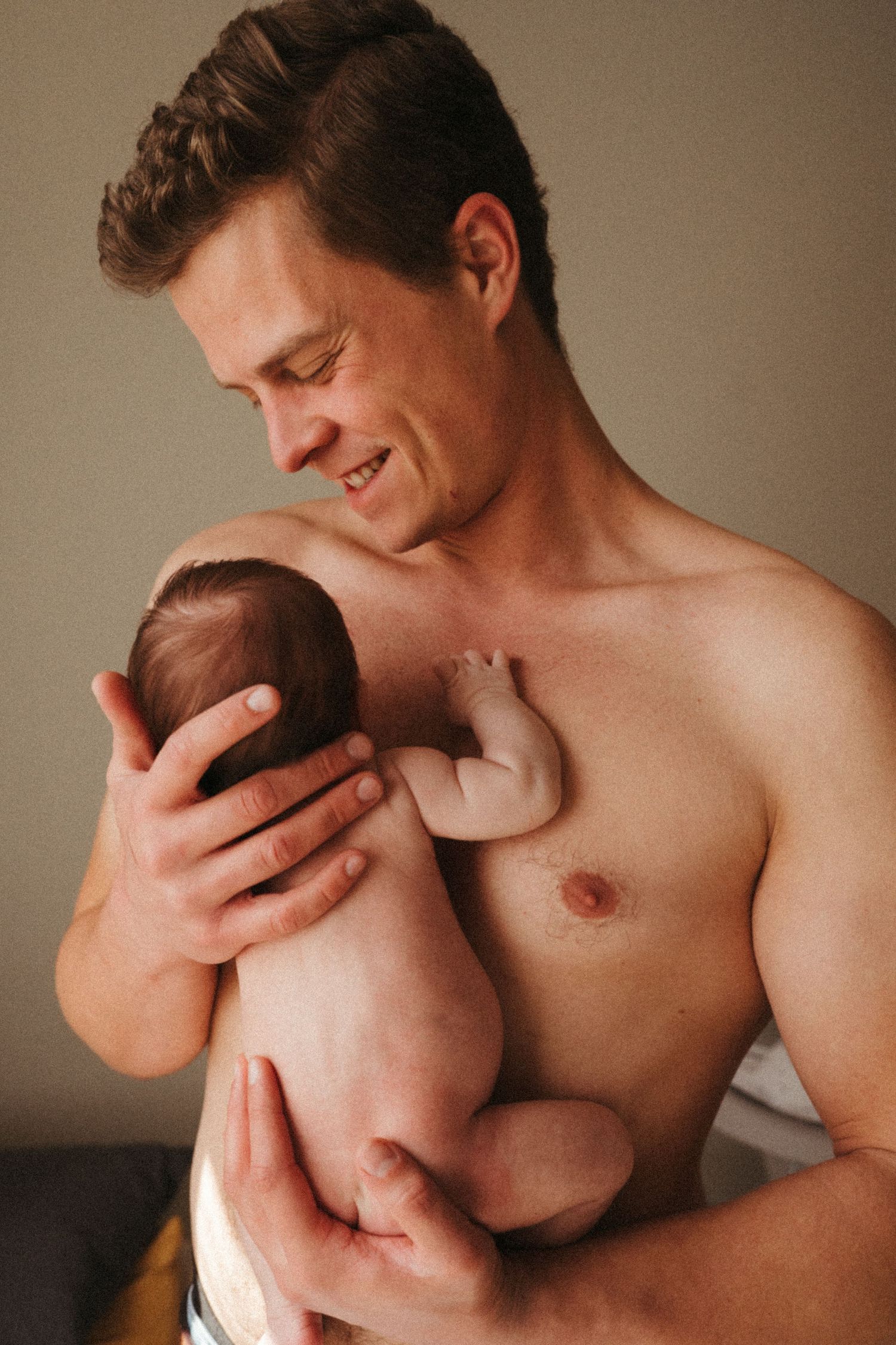 Warm portrait series capturing joyful bonding moments with a newborn.