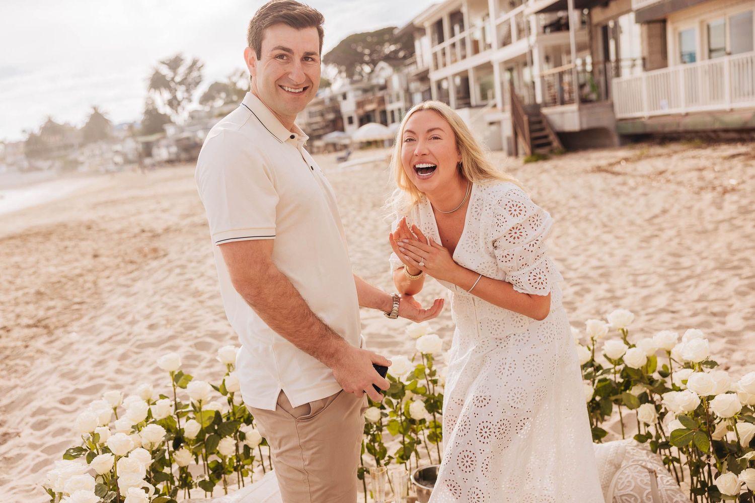Just engaged couple laughing at the photographer after just proposing at Montecito beach during their engagement photo session.