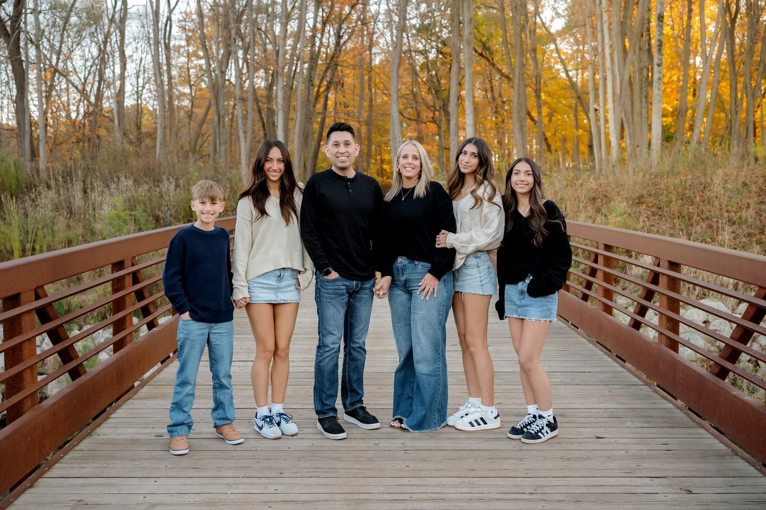 Extended family portrait taken at sunset in a meadow with natural lighting.