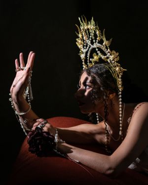 Evocative portrait of a woman with jeweled headdress and bead chains around hands
