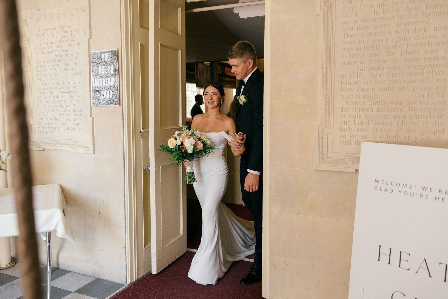 Wedding preparations taking place in an elegant hallway with cream colored walls.
