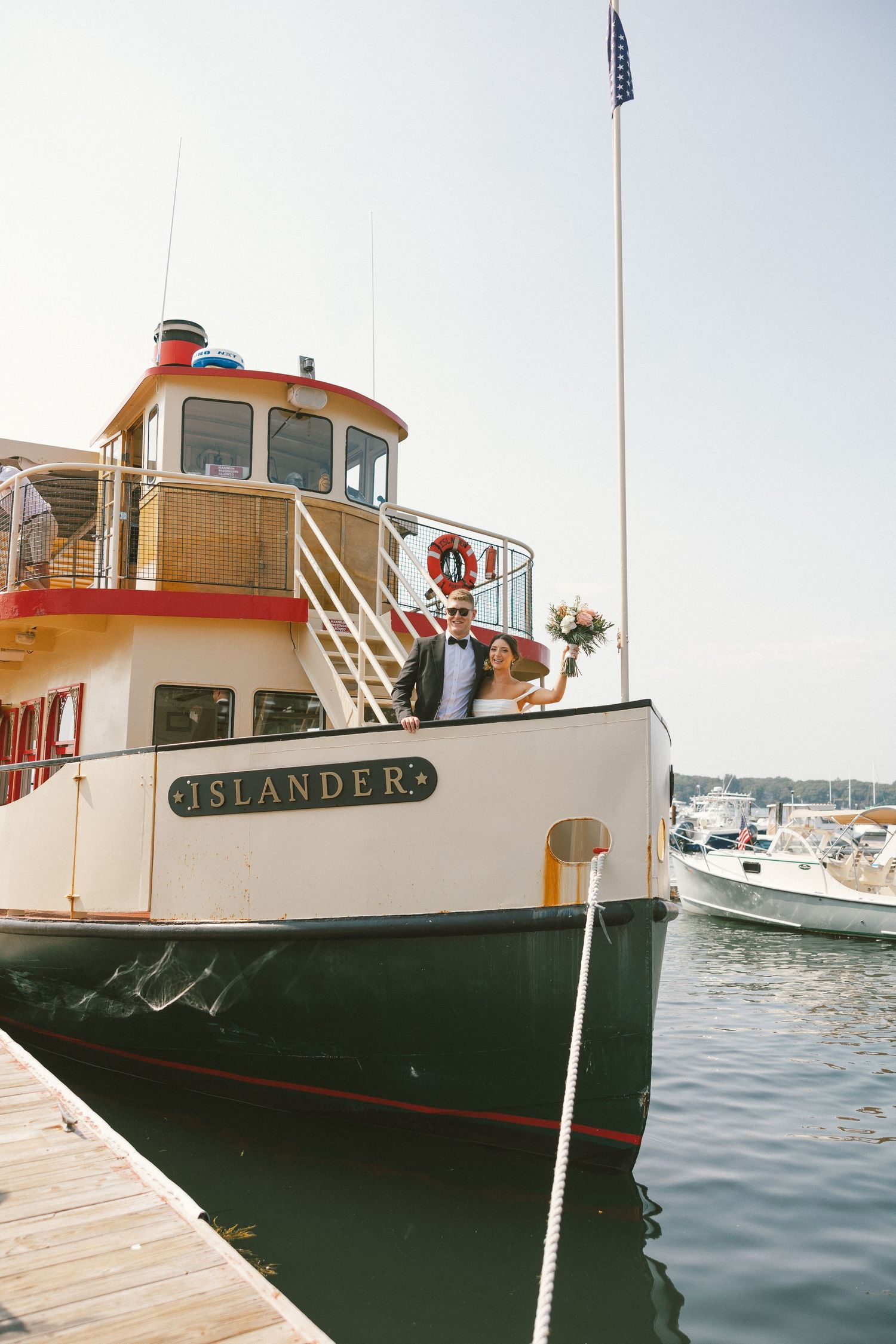 Classic white and orange ferry boat named Islander docked at harbor.