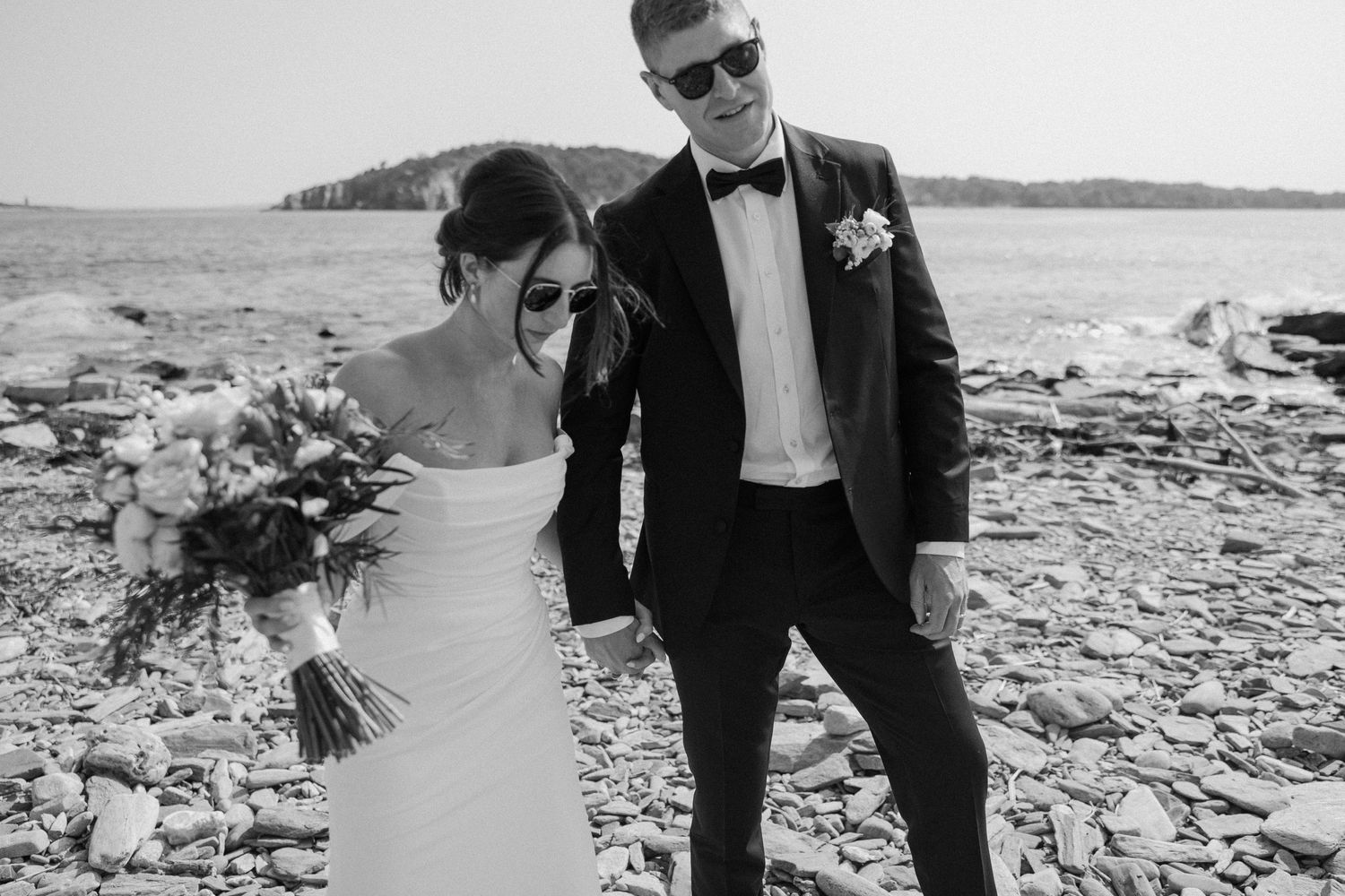 Black and white wedding photography session on a rocky beach.