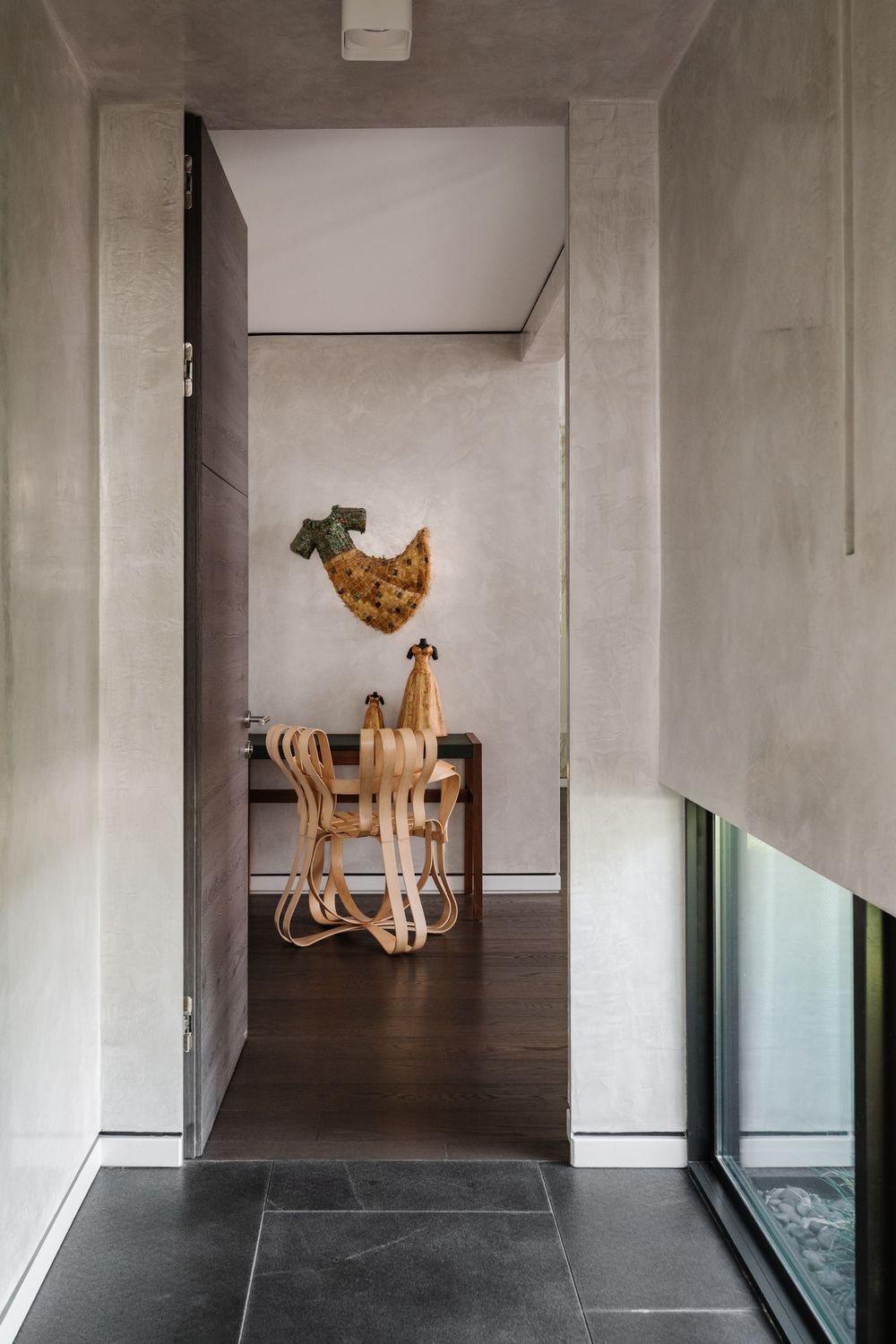 Plastered hallway looking into the room with table and chair