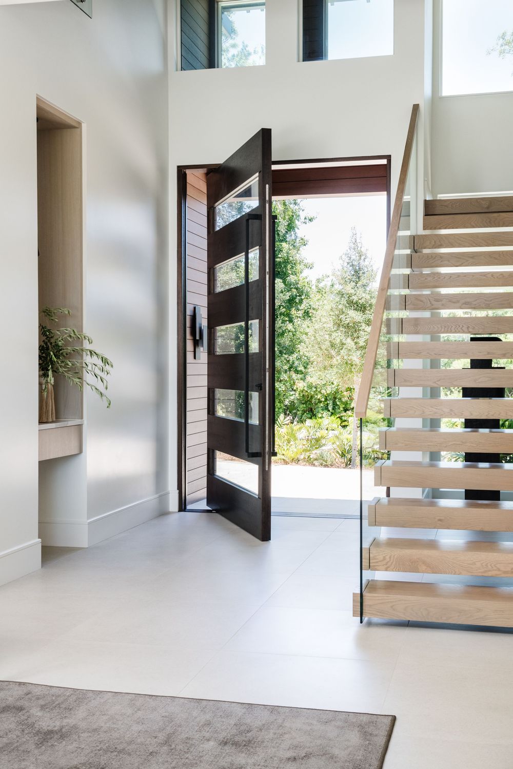 Large scale pivot door leading into big open entryway