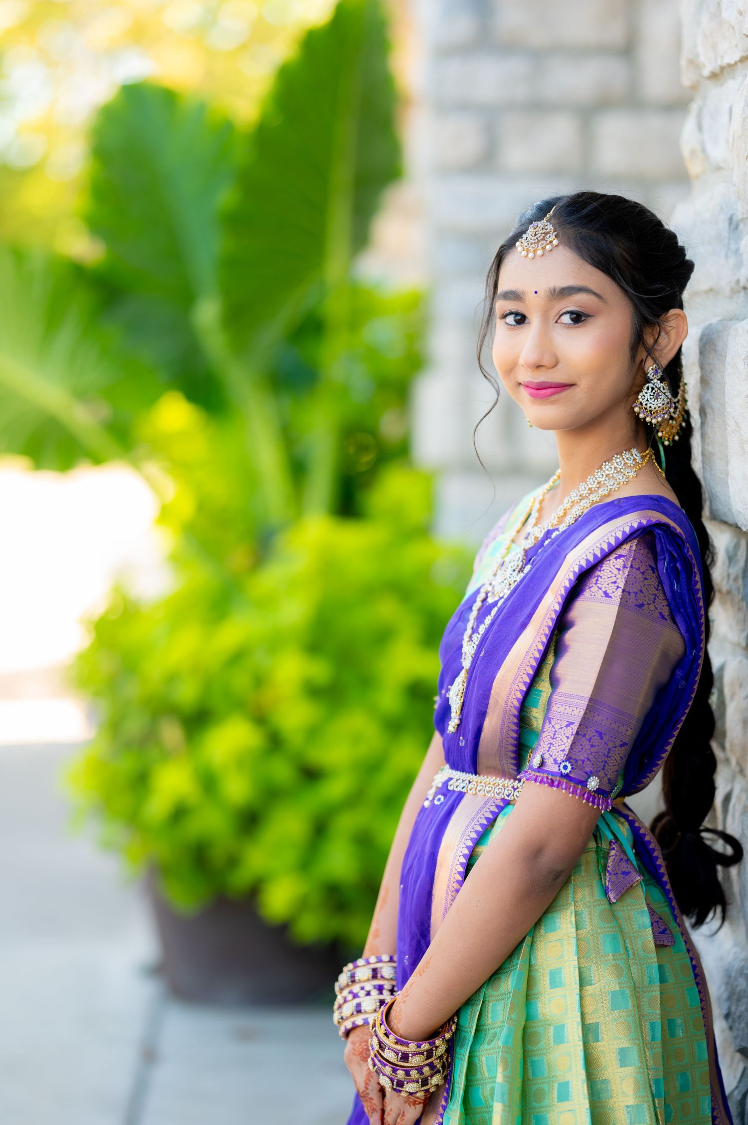 Traditional Indian attire in purple and mint green photographed against a light stone backdrop.