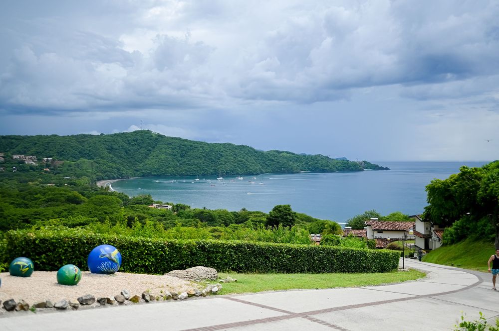 Panoramic view of a tropical coastline with green hills and ocean views.