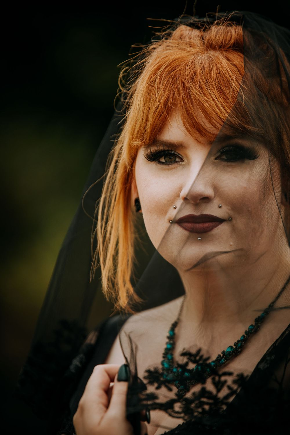 Dark gothic fashion portrait features black lace, turquoise jewelry and dramatic makeup.