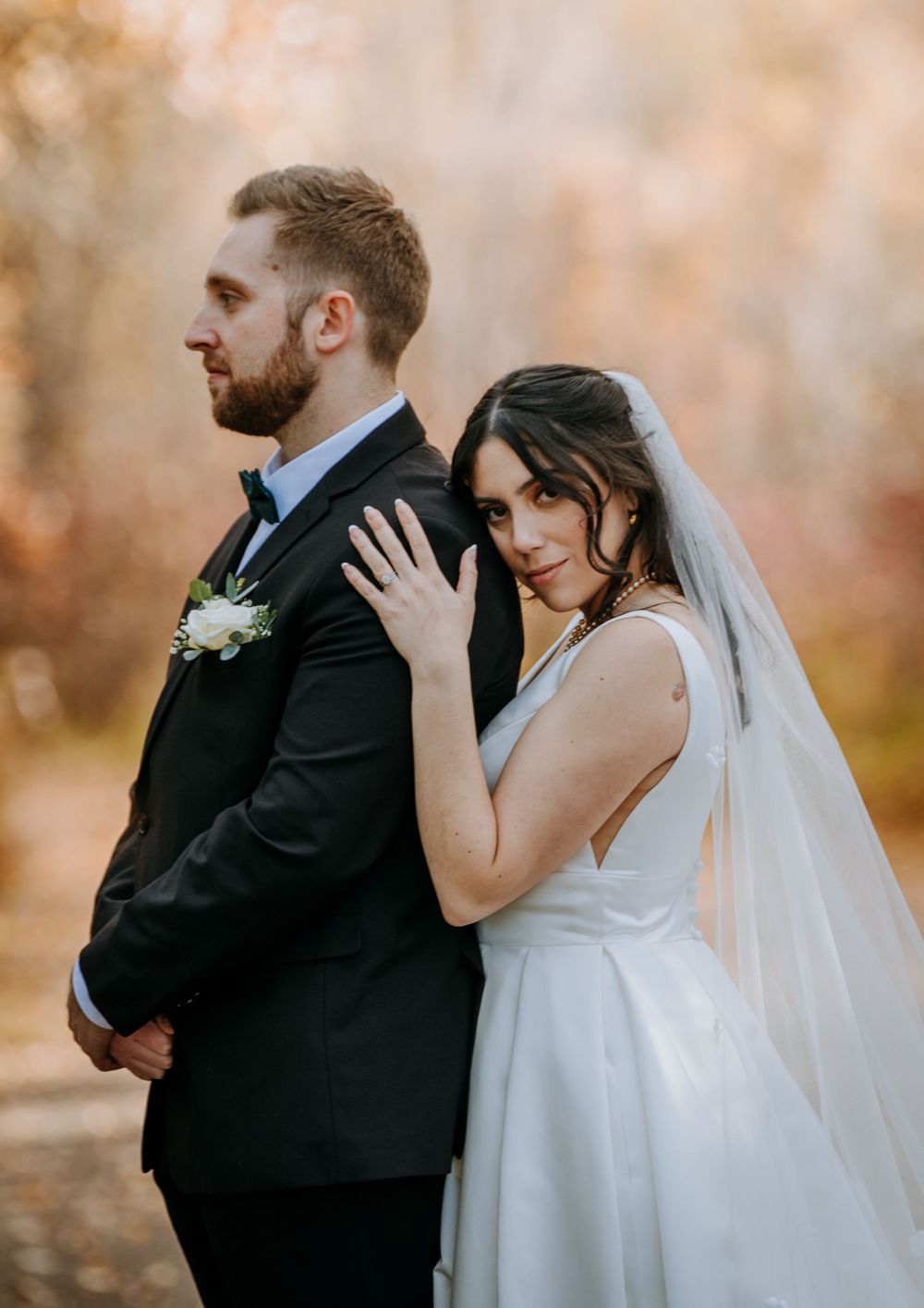 Romantic wedding portrait with autumn foliage in background.