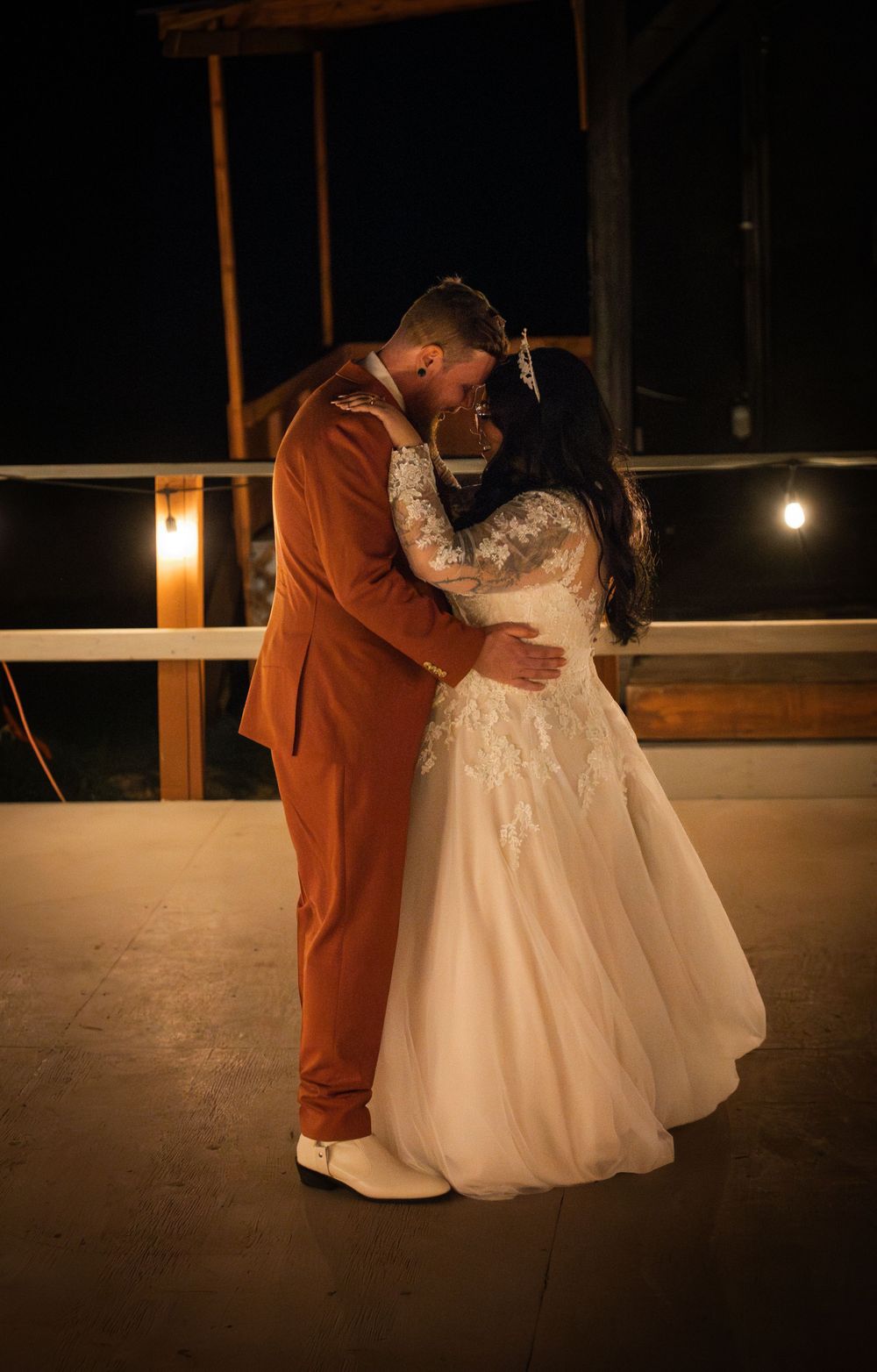 A romantic evening dance on a deck with warm lighting and rustic wooden details.