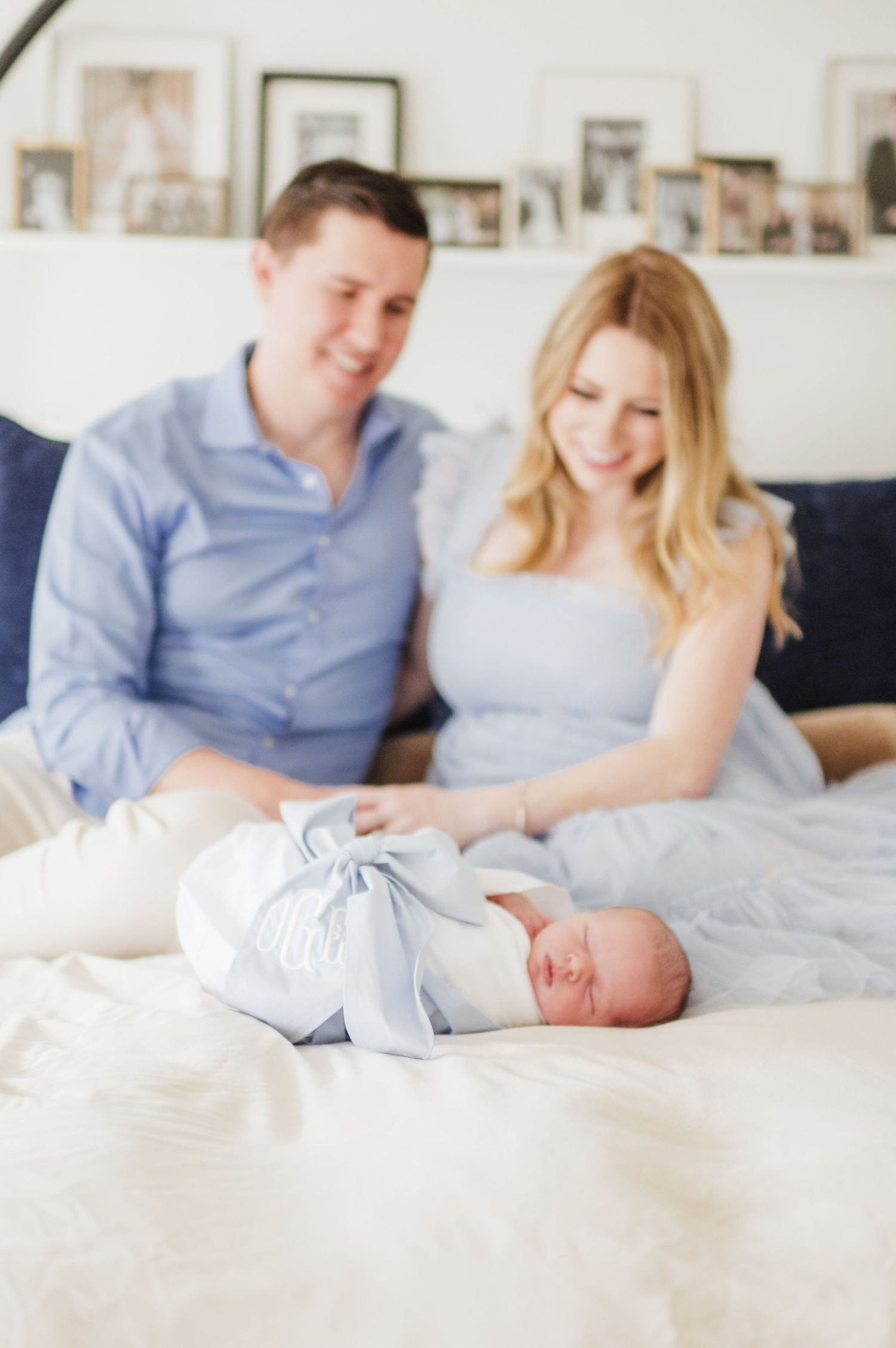 Intimate lifestyle newborn photography series showing parents bonding with baby indoors.