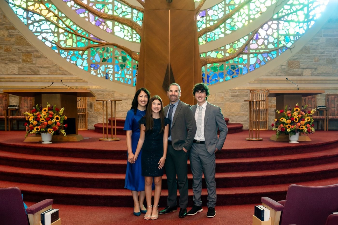 Family of 4 posing at the bimah of a synagogue, shot by Milwaukee event photographer Rachel Dickman