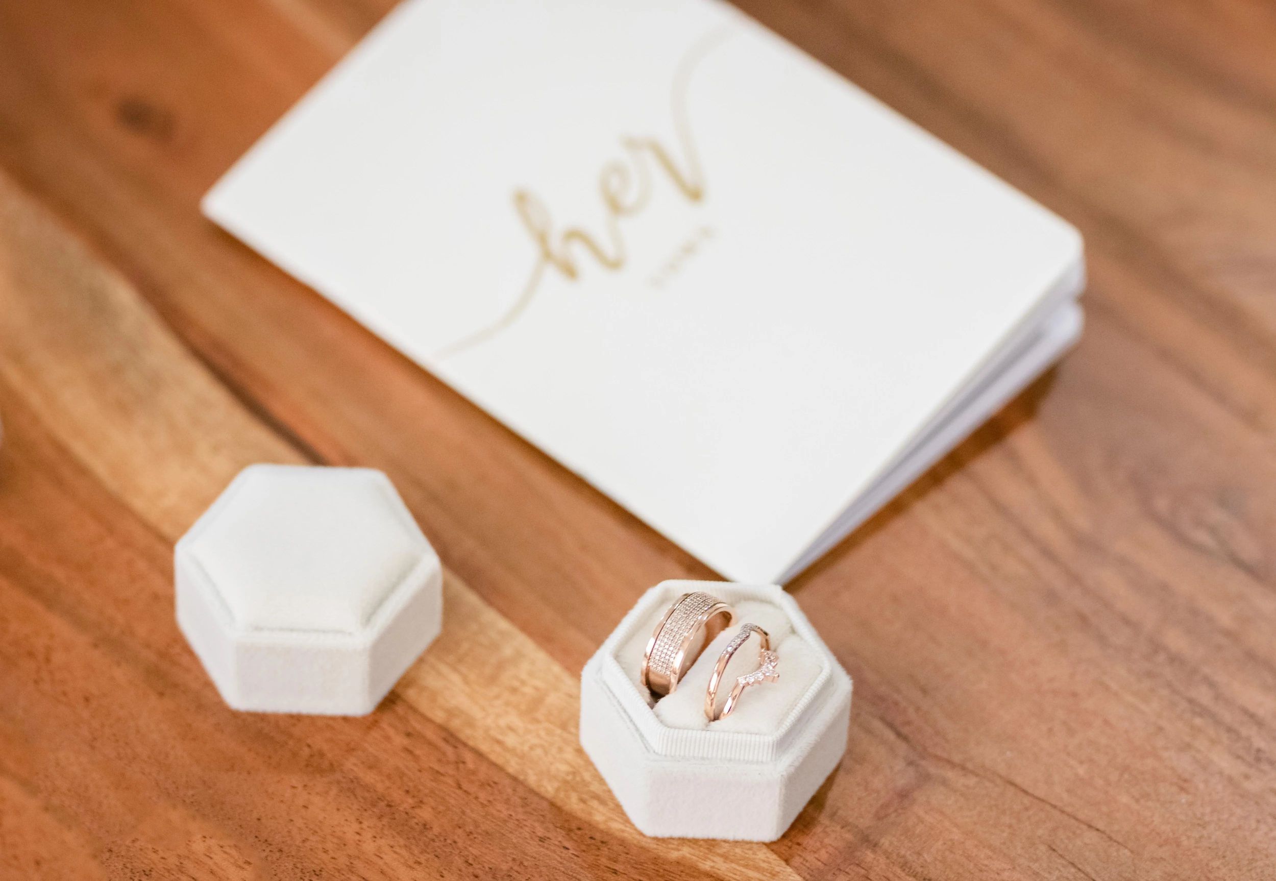 Wedding rings and jewelry details arranged on a wooden surface for a special occasion.