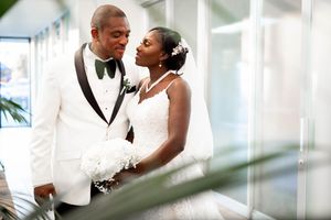 Romantic wedding photography in Orange County featuring a bride and groom embracing during an indoor ceremony. Natural, candid wedding portr
