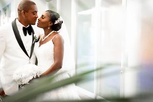 Romantic wedding photography in Orange County featuring a bride and groom embracing during an indoor ceremony. Natural, candid wedding portr