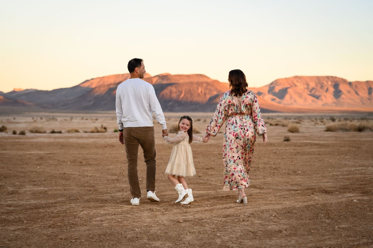 Family relaxing against desert backdrop during golden hour. Family portrait photography in Las Vegas. Family photographer Las Vegas.