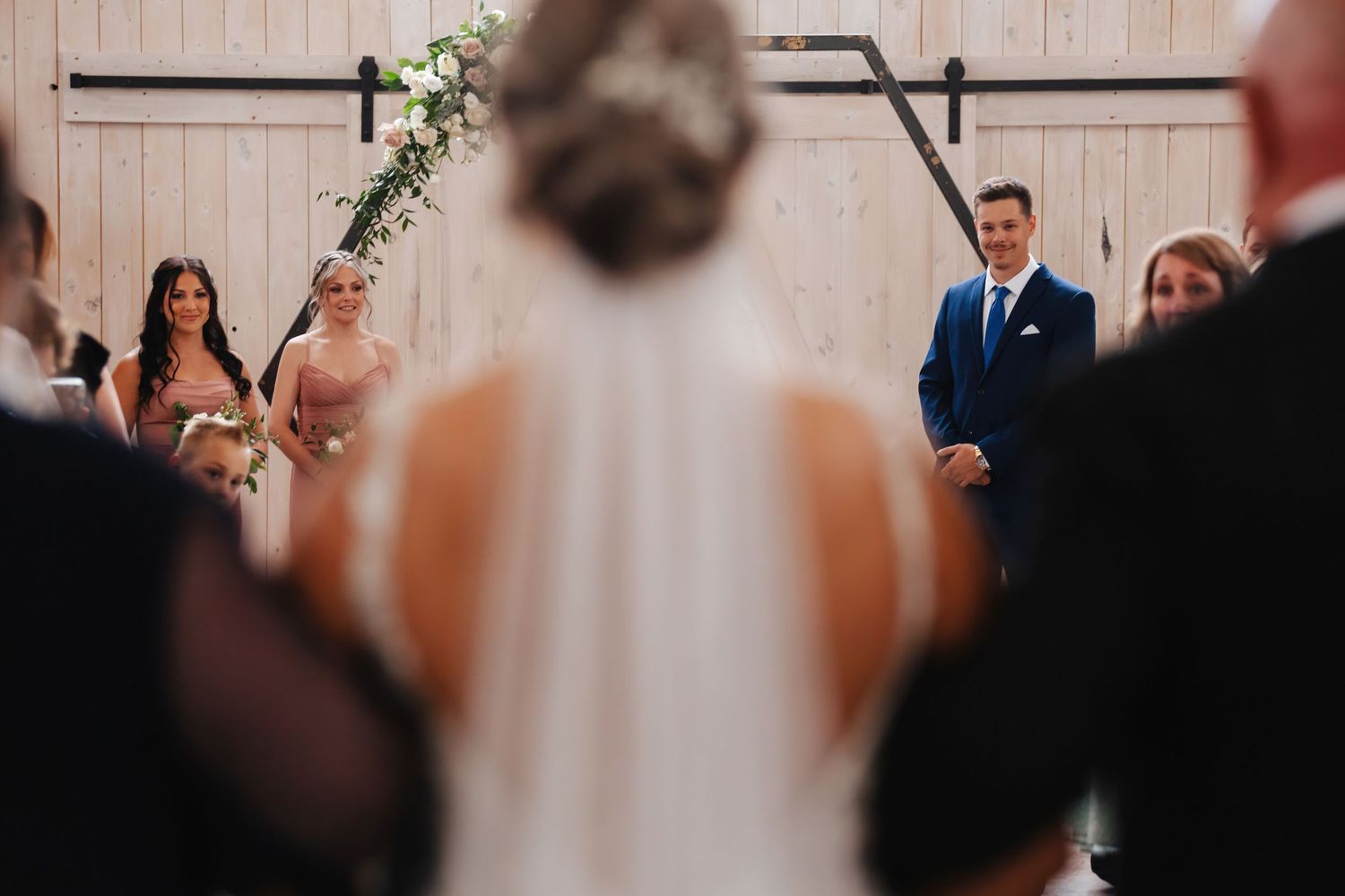 Wedding ceremony guests seated in rows at an indoor venue.