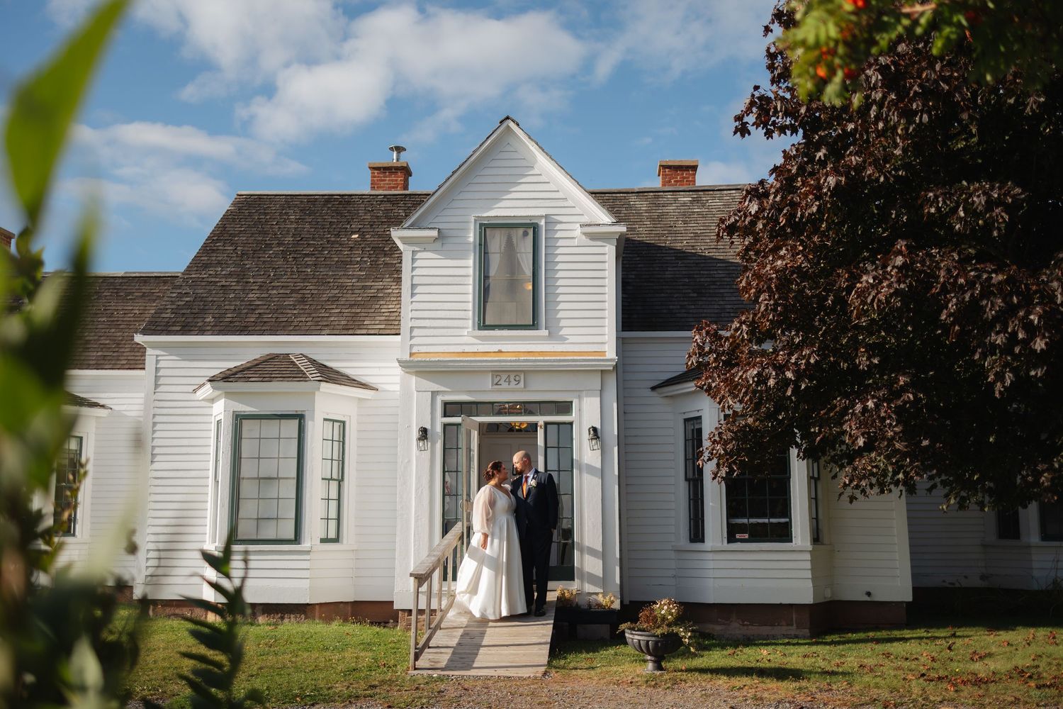 Row of classic white residential houses under a blue sky. Wedding couple in front.