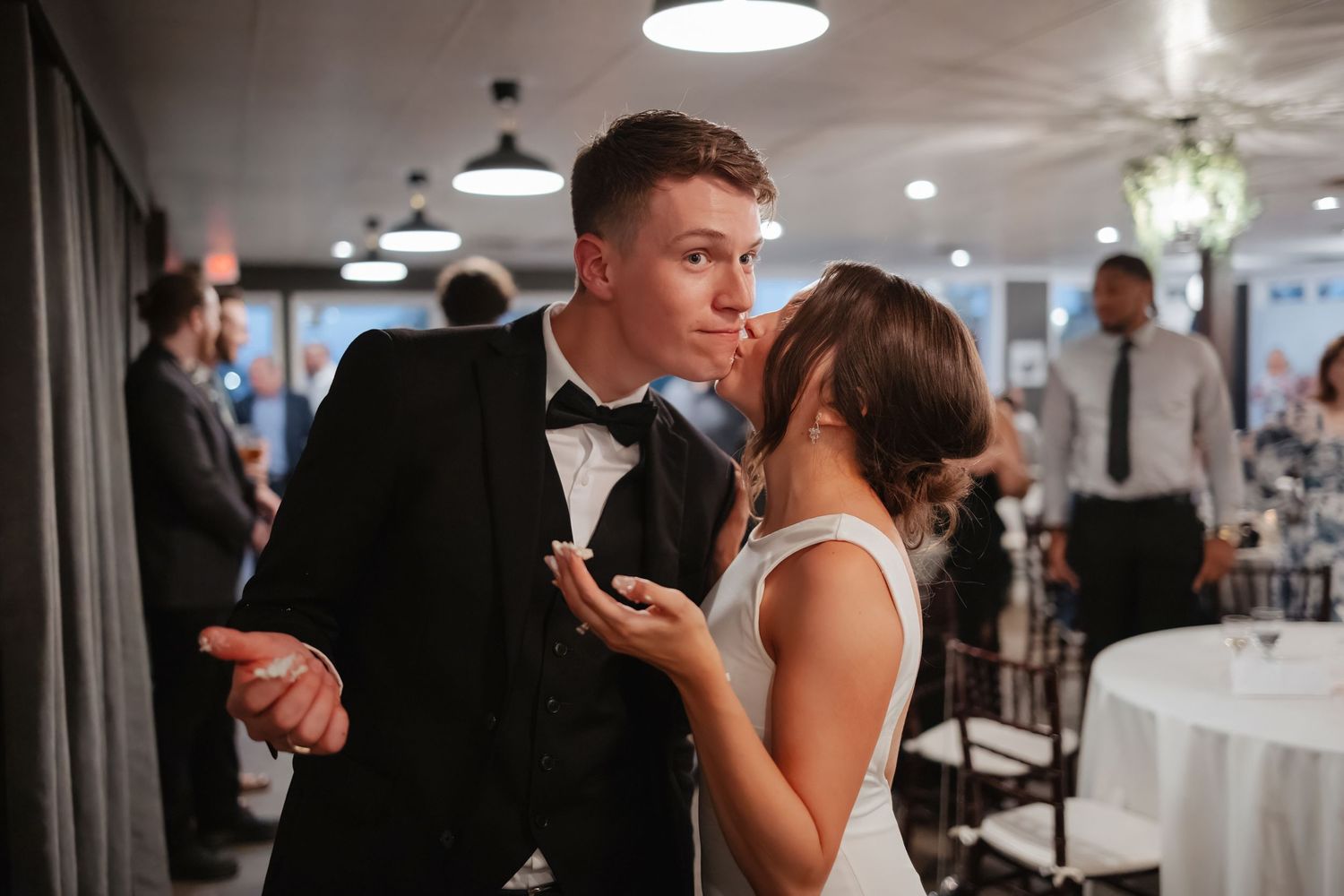 Wedding reception dance floor with guests celebrating under warm lighting and hanging decor.
