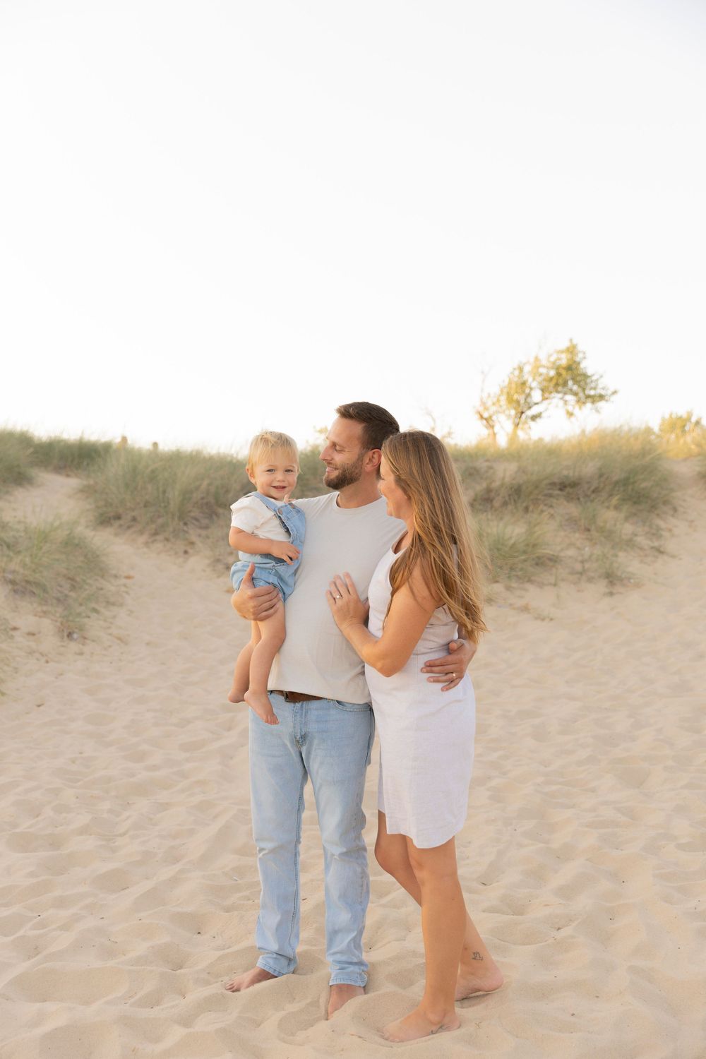 family wearing cream, beige and jeans on the sand dunes for a beach photo