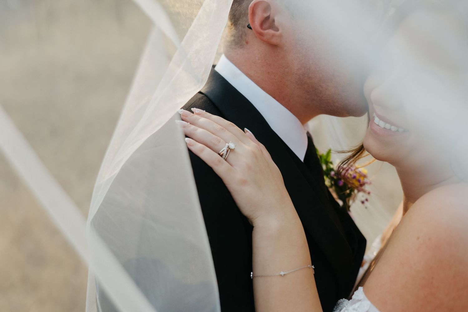 Winter wedding portrait in a minimalist snowy landscape with bare trees.