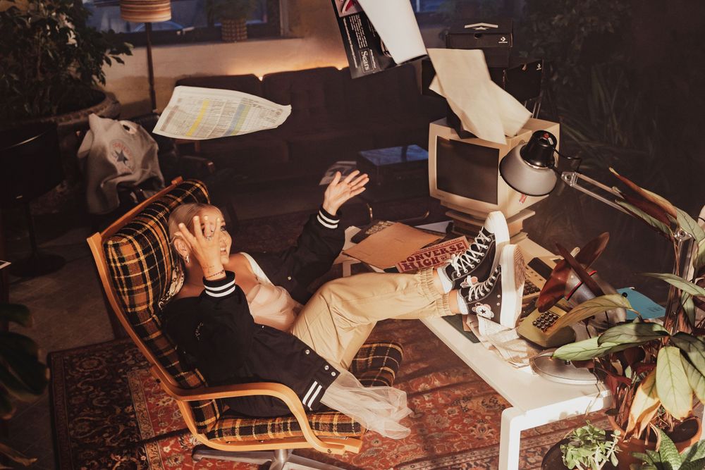 Adidas lifestyle photo of a person wearing a white Adidas tracksuit and sneakers in an outdoor urban setting
