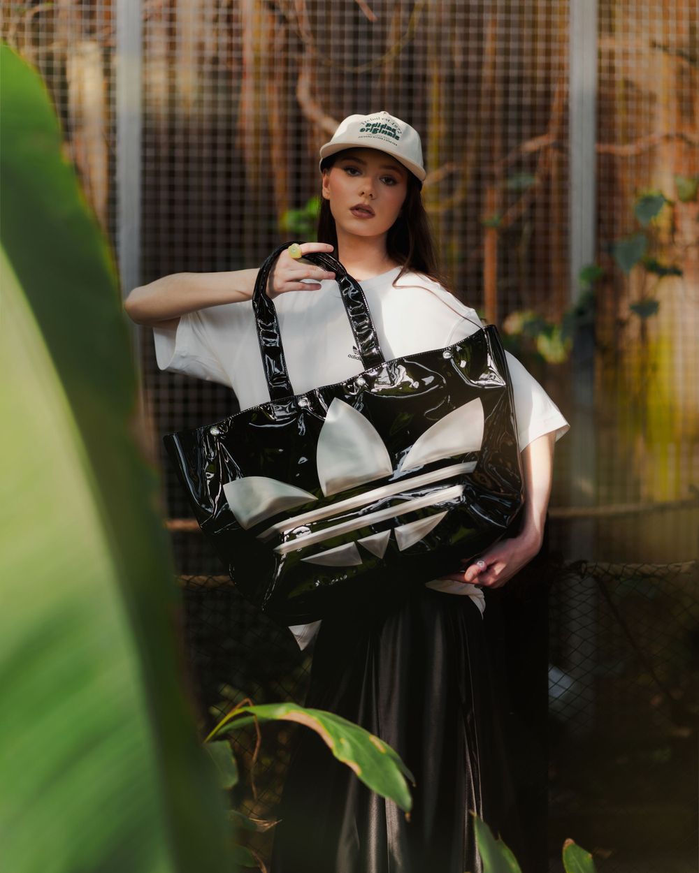 Portrait photo in an outdoor setting with lush vegetation and dark atmospheric lighting