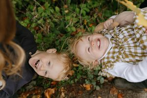 A series of playful fall portraits showing someone lying in autumn leaves with plaid clothing and joyful expressions.