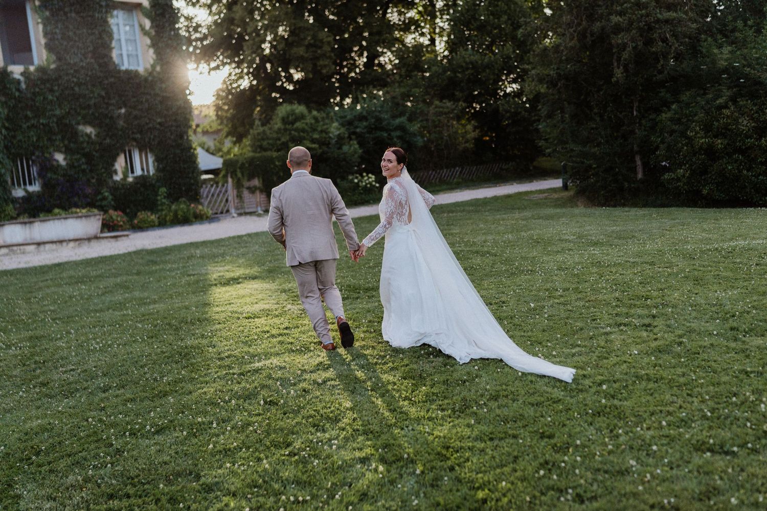Couple de mariés courant devant le château de césarges en région Rhône-Alpes