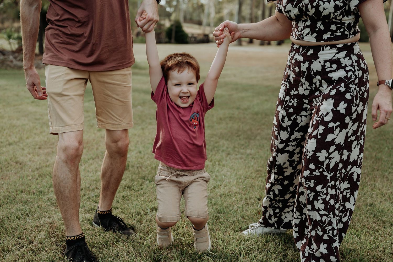 Family members playing and interacting on grass in outdoor gladstone garden setting.