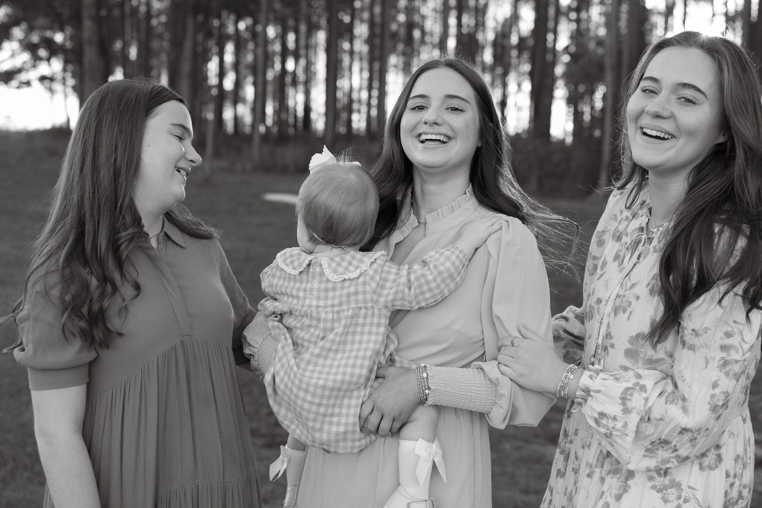Multi-generational family poses together for a portrait in an autumn forest setting.